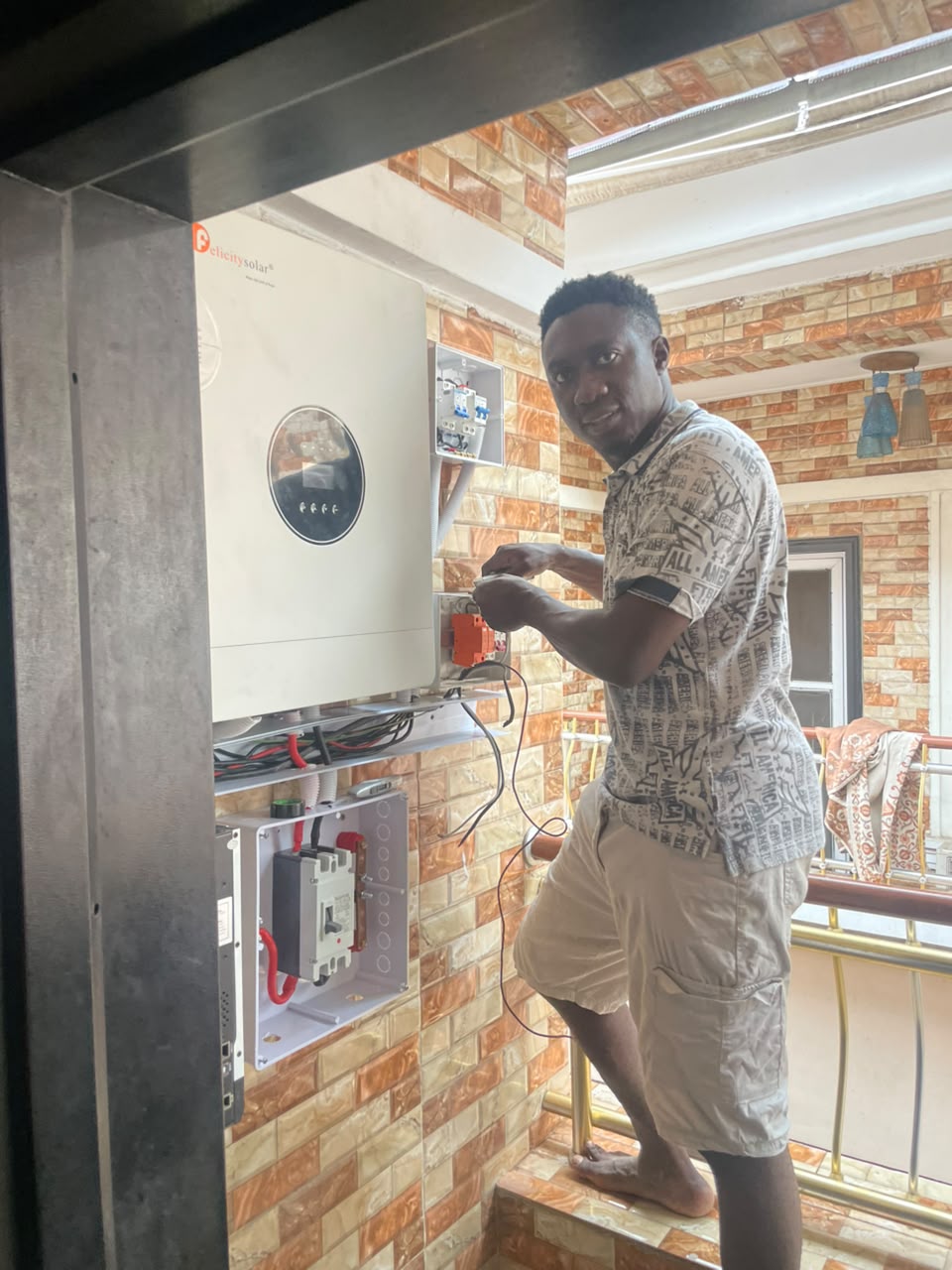 Technician working on a Felicity Solar inverter installation with circuit breakers and wiring