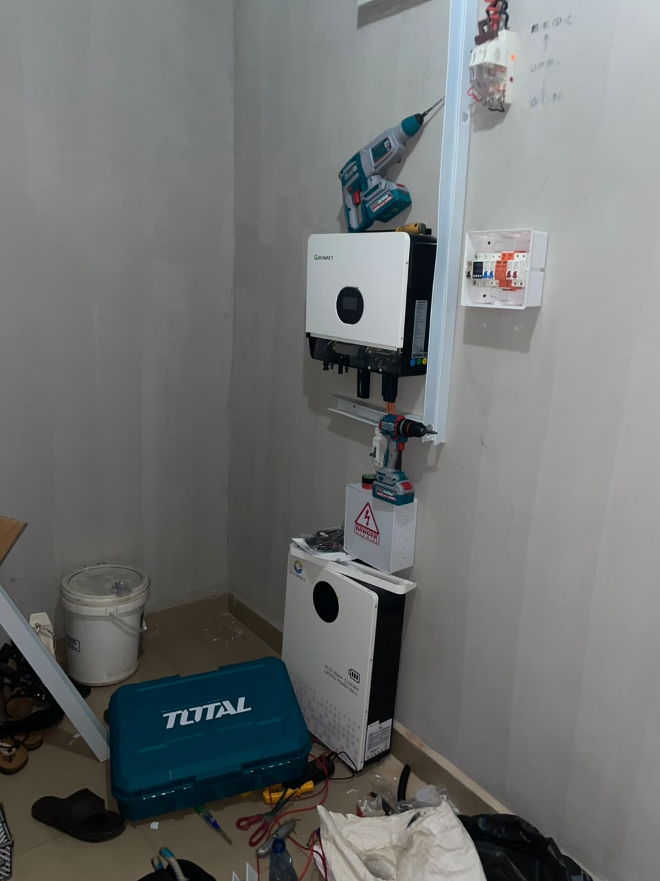 Technician installing an inverter and battery system on site