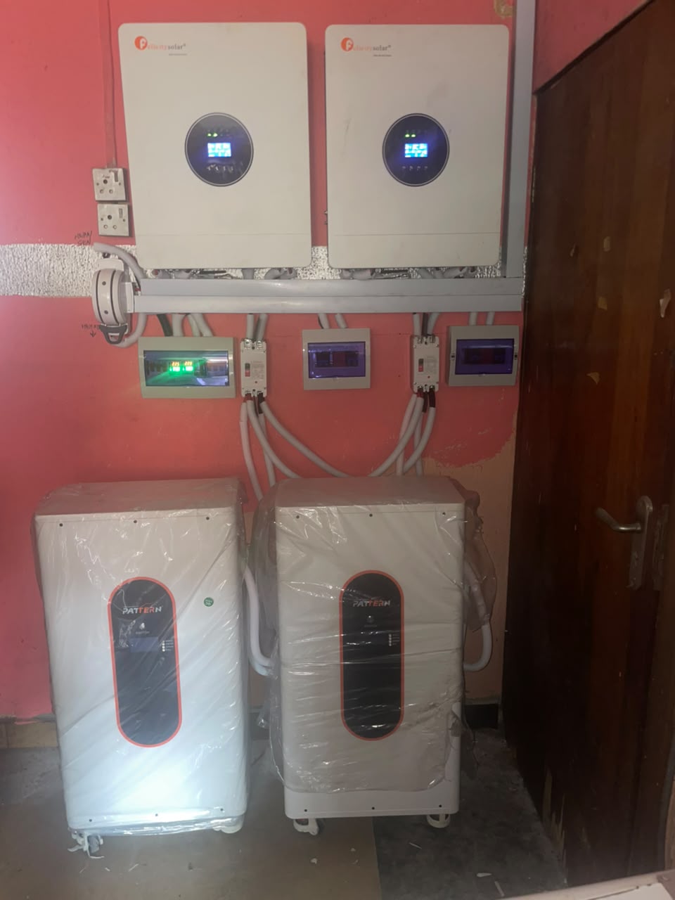 Two wall-mounted inverters with distribution boards and battery units